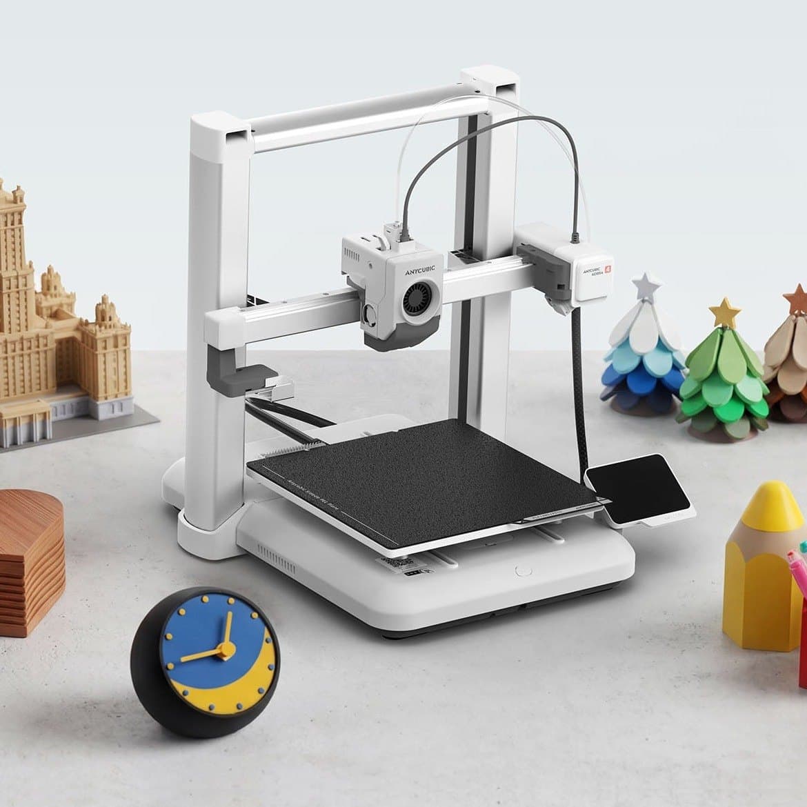 Anycubic Kobra 4 на рабочем столе с напечатанными моделями